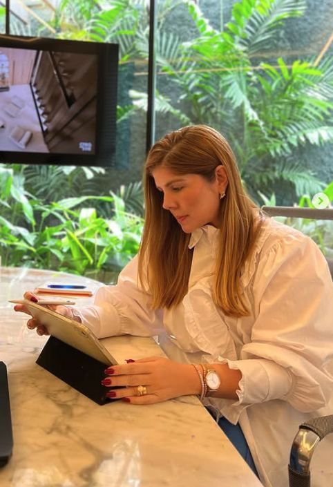 Laís Costa, arquiteta, revisando projeto em ambiente residencial de alto padrão